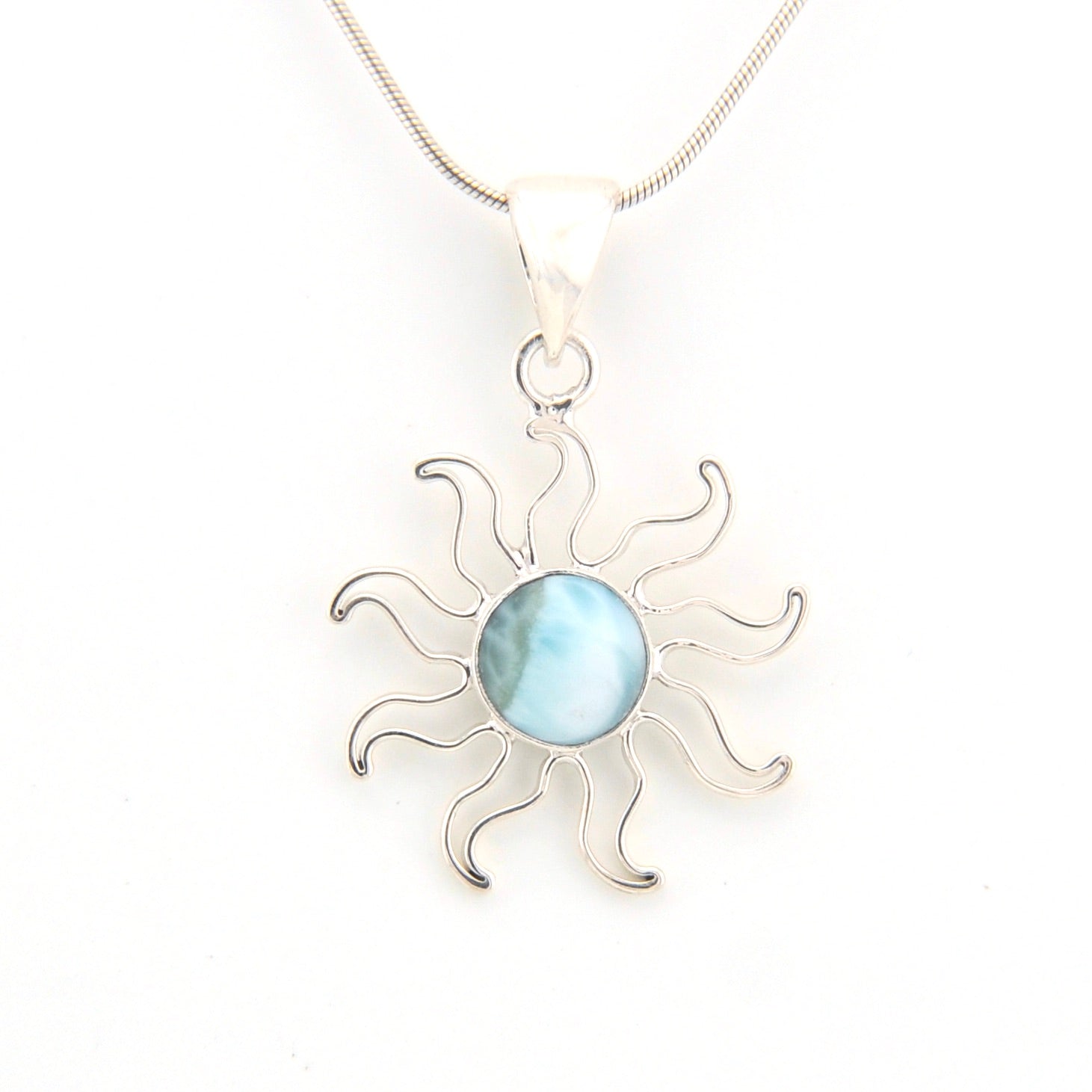 Silver sun-shaped pendant with a blue stone on a white background