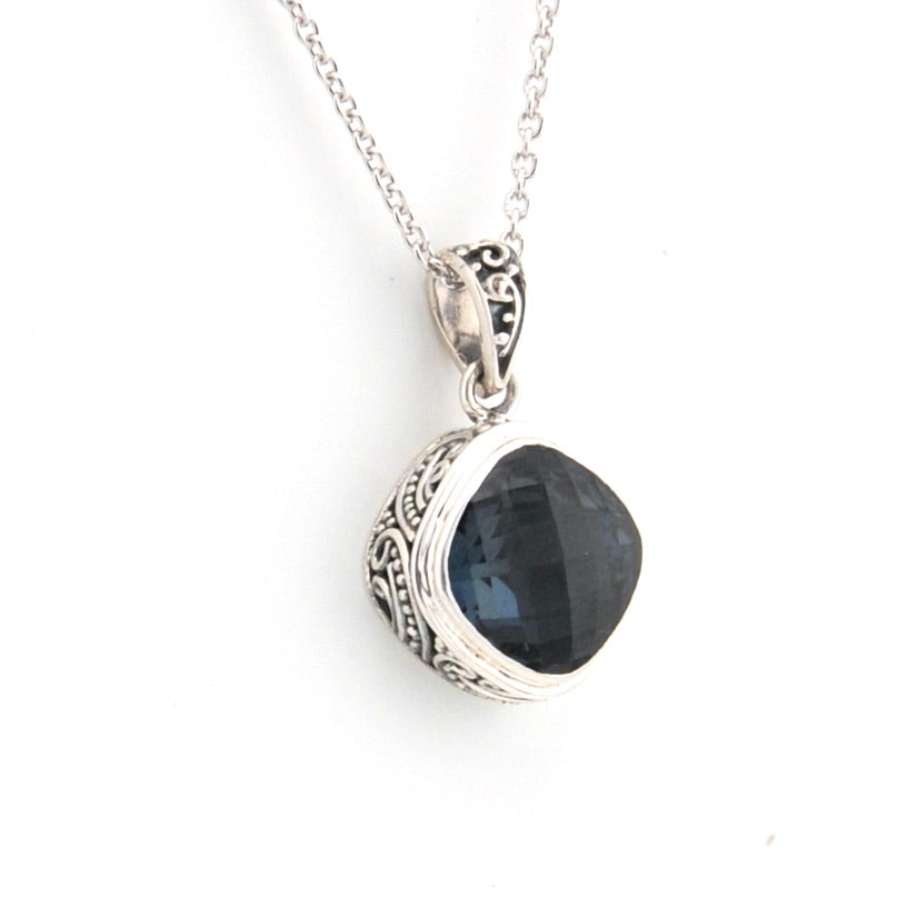 Silver pendant with a blue stone on a white background