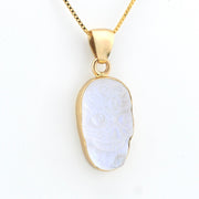 Gold pendant with a white stone on a white background