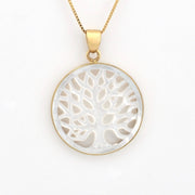 Gold necklace with a white tree-of-life pendant on a white background
