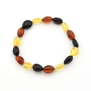 A beaded stretch bracelet made of alternating translucent oval beads in amber brown, deep black, and bright yellow, displayed on a clean white background.