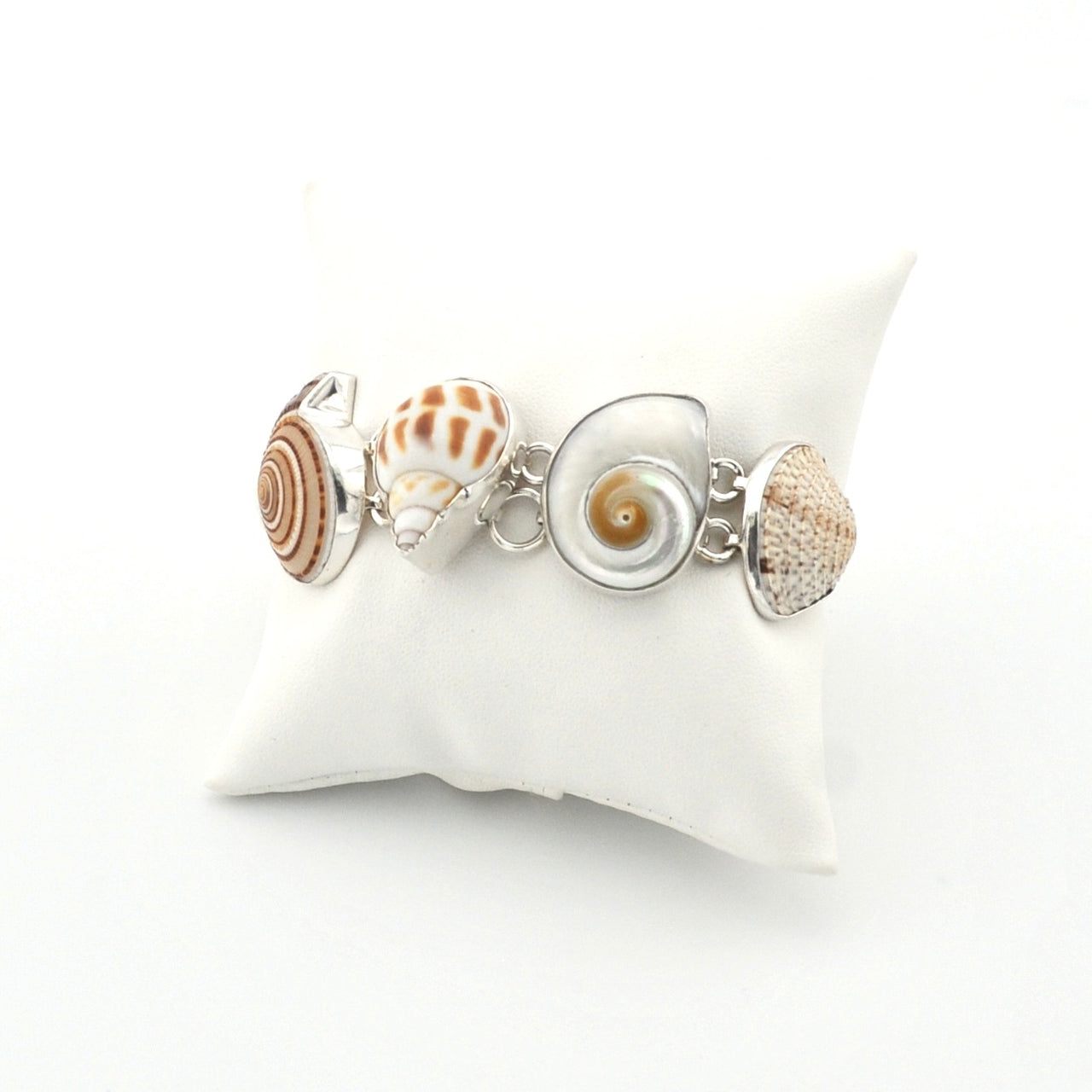 Bracelet with shell-shaped charms on a white cushion