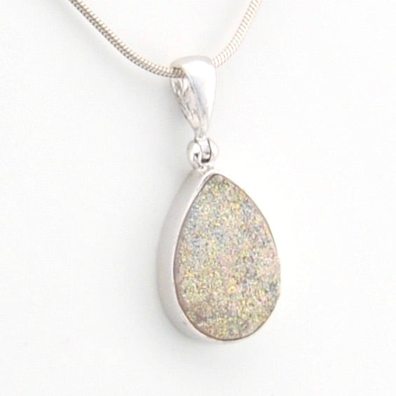Teardrop-shaped silver pendant on a white background