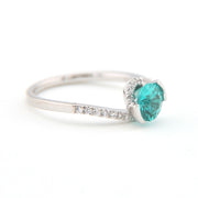 Silver ring with a green gemstone on a white background