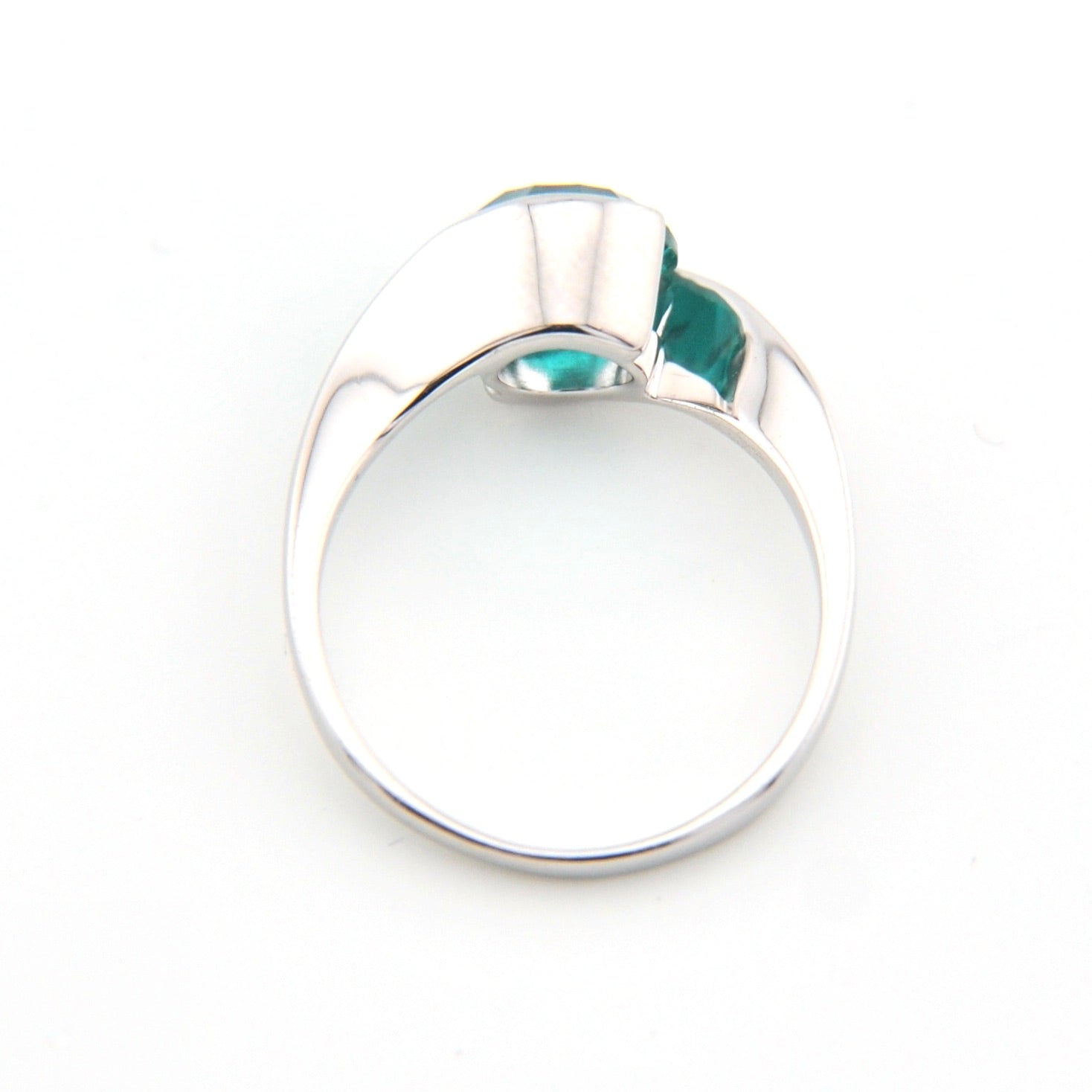 Silver ring with a green gemstone on a white background