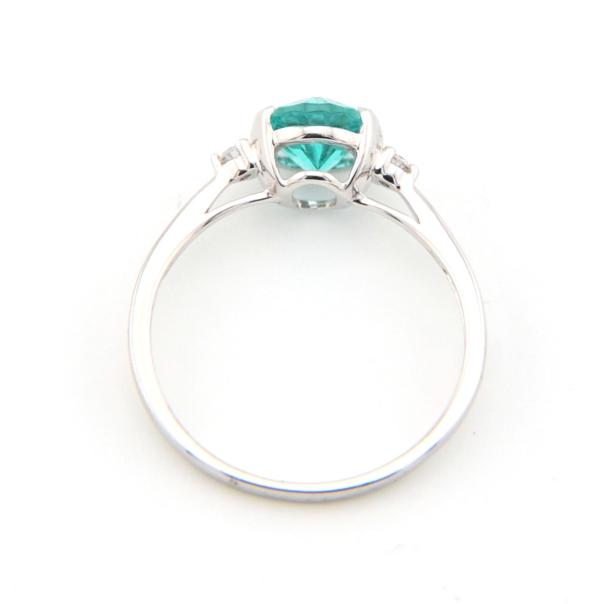 Silver ring with a green gemstone on a white background