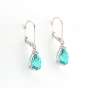 Teardrop-shaped turquoise earrings with silver hooks on a white background