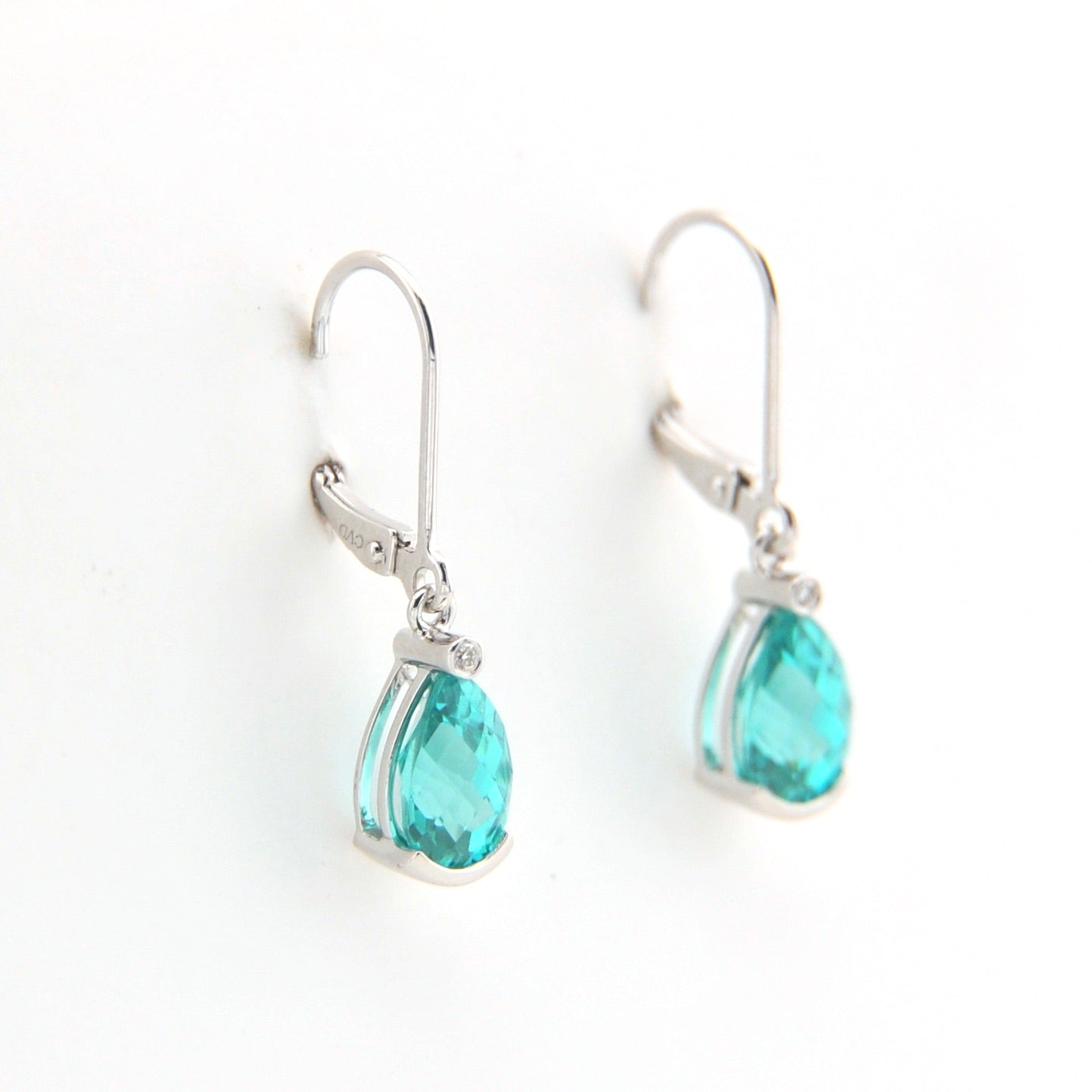 Teardrop-shaped turquoise earrings with silver hooks on a white background