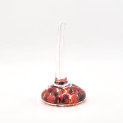 Decorative ring holder with a red and brown pattern on a white background