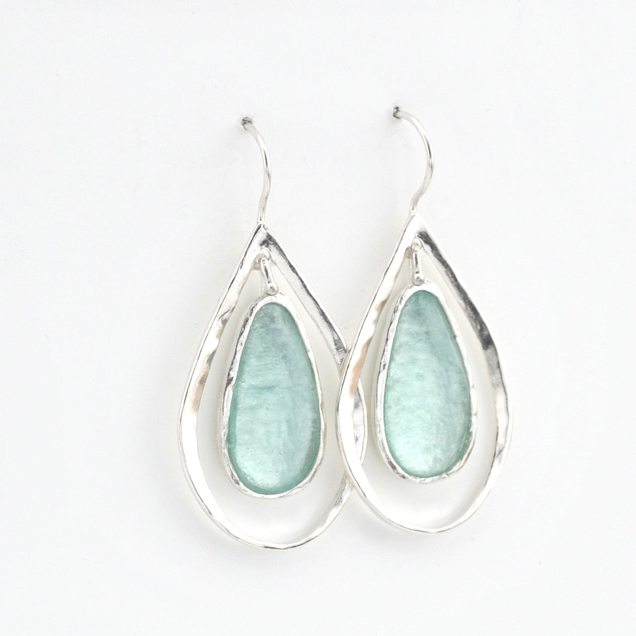 Teardrop-shaped earrings with light blue glass on a white background