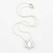 Silver necklace with a star-shaped pendant on a white background