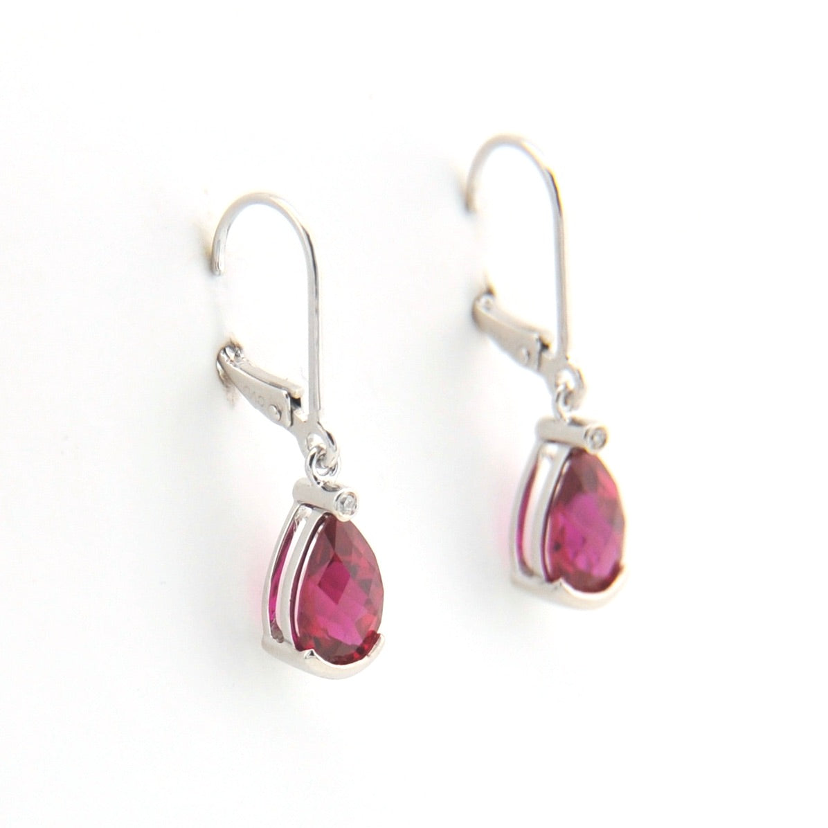 Silver earrings with pink gemstones on a white background