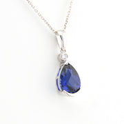 Teardrop-shaped blue gemstone pendant on a white background