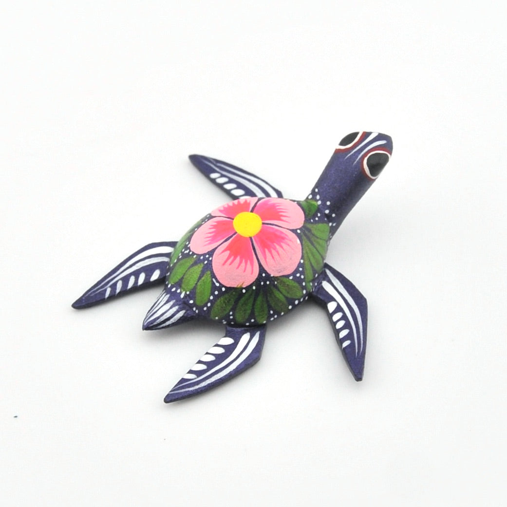 Decorative turtle figurine with floral design on a white background