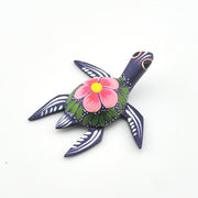 Decorative turtle figurine with floral design on a white background