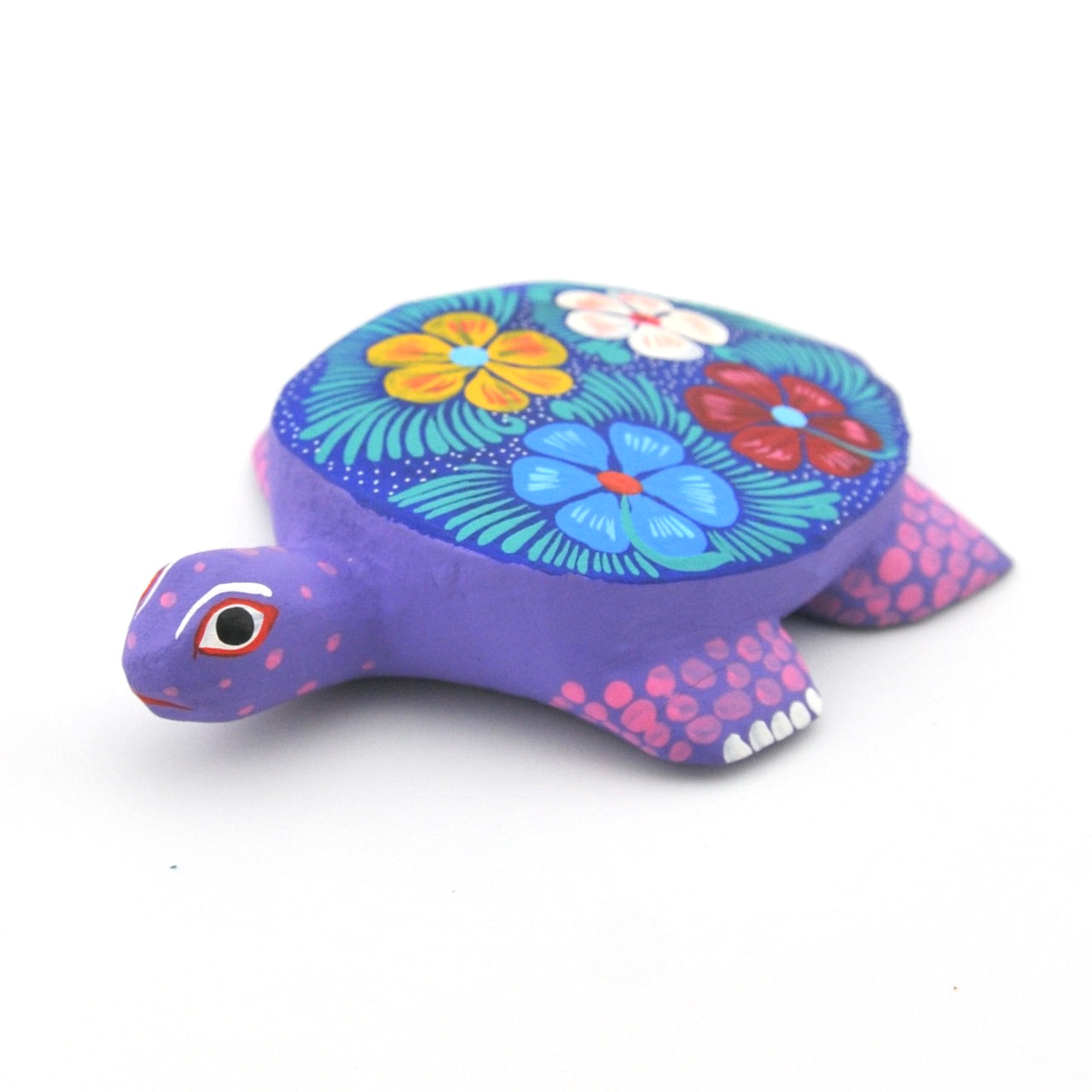 Colorful turtle figurine with floral design on a white background