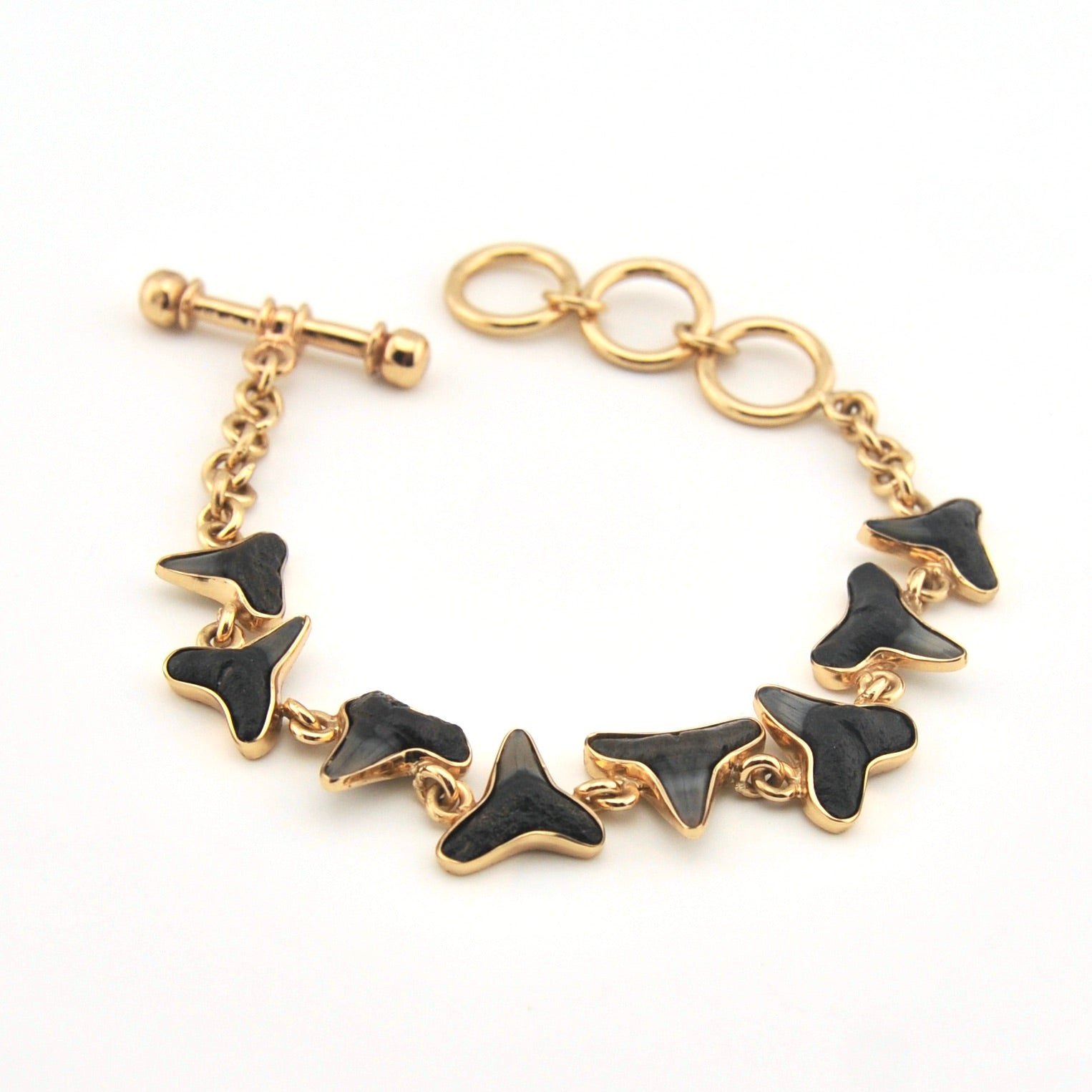 Gold bracelet with black butterfly-shaped charms on a white background
