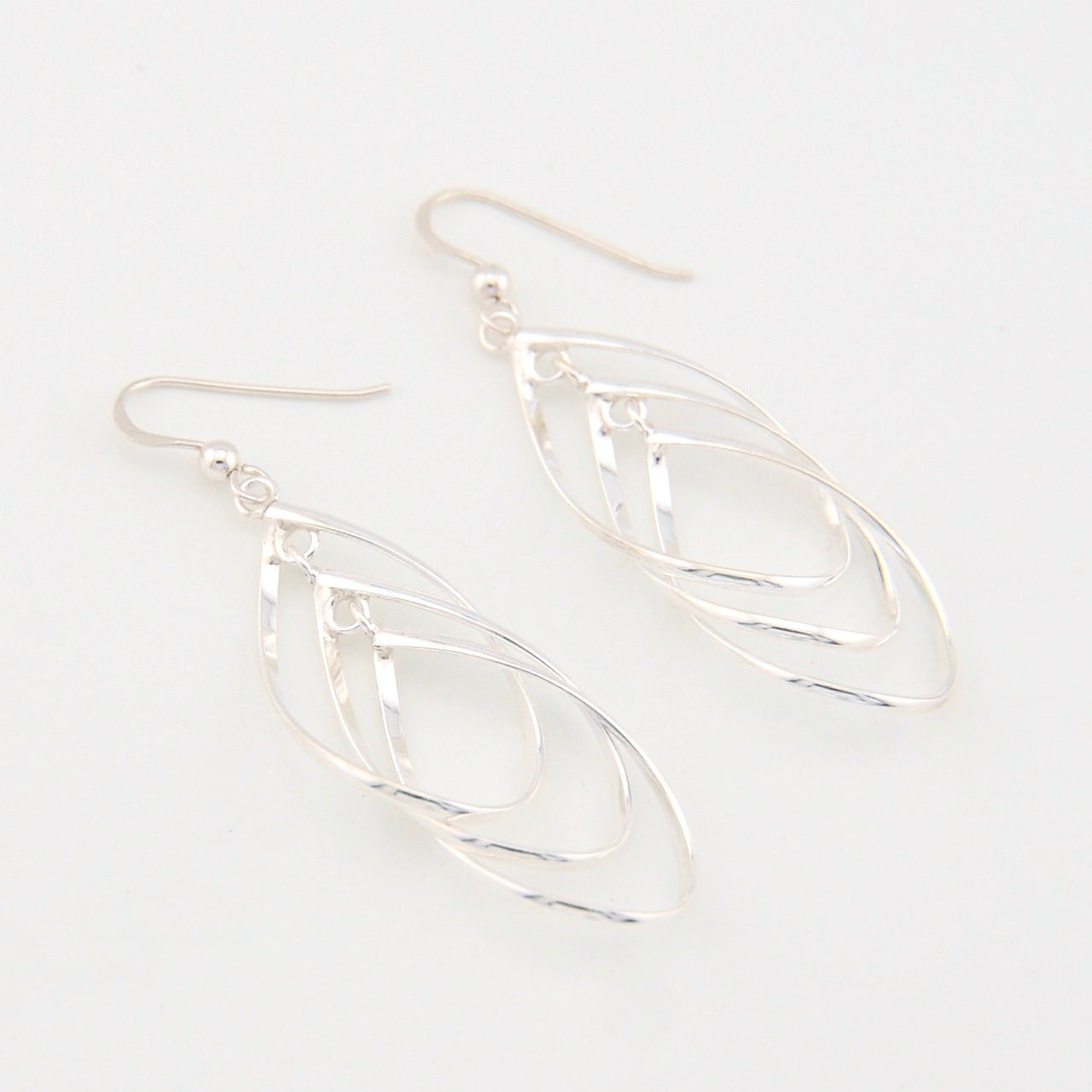 Silver tear-shaped earrings on a white background