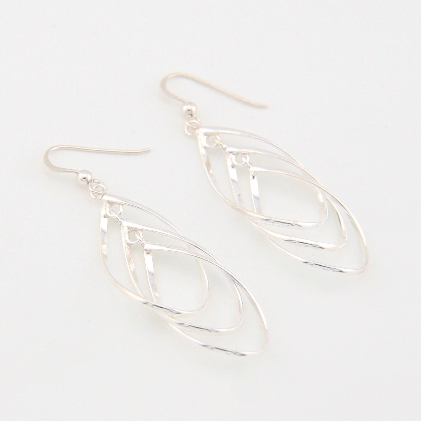 Silver tear-shaped earrings on a white background