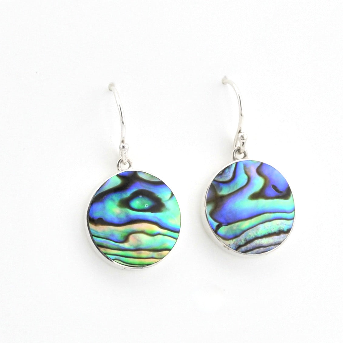 Abalone shell earrings on silver hooks against a white background