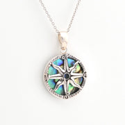 Silver necklace with a round pendant featuring a compass design on a white background