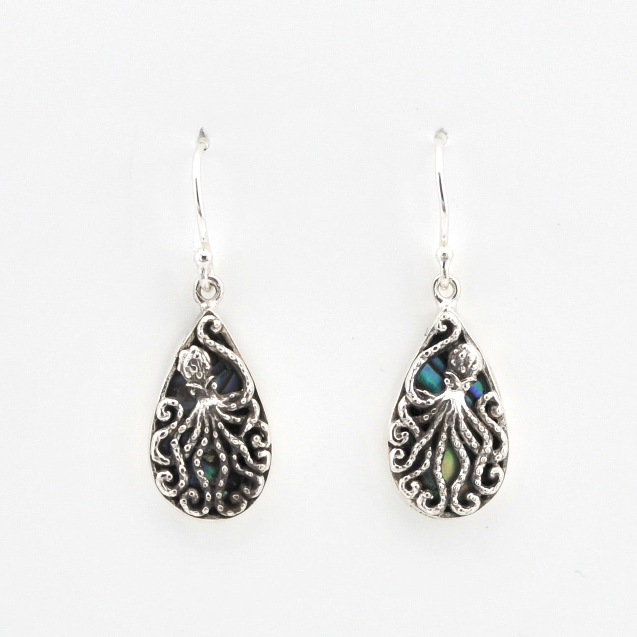 Pair of silver teardrop earrings with intricate designs on a white background