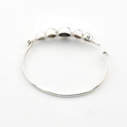 Silver bracelet with embedded stones on a white background