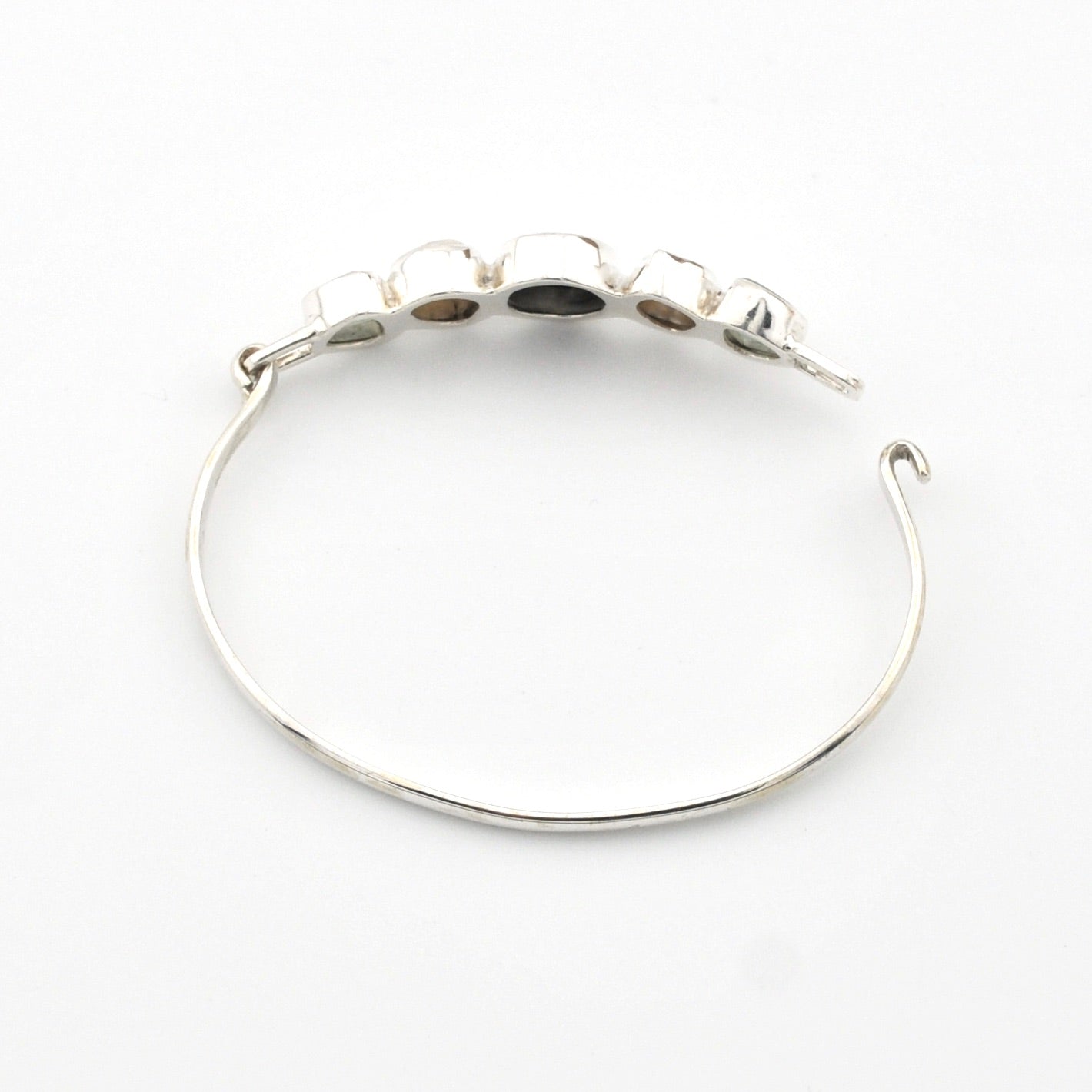 Silver bracelet with embedded stones on a white background