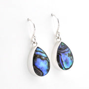 A pair of silver teardrop dangle earrings with iridescent abalone shell inlays showing blue, green, and purple hues, set against a plain white background.