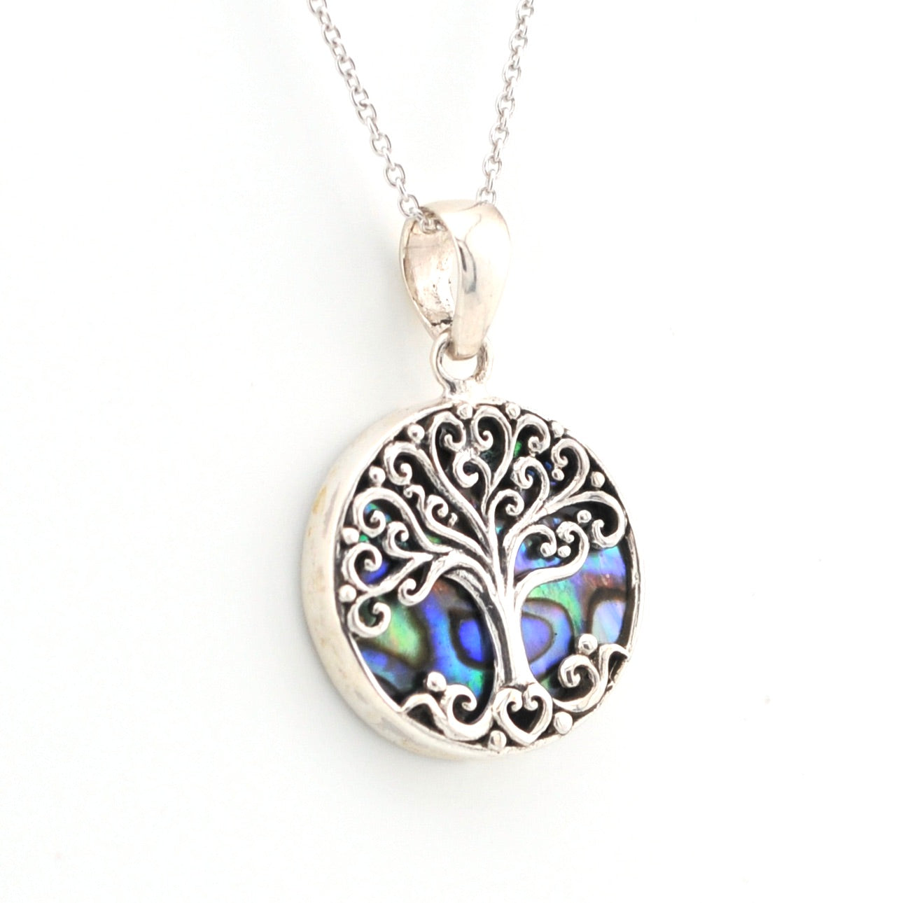 Silver tree of life pendant with abalone shell inlay on a white background