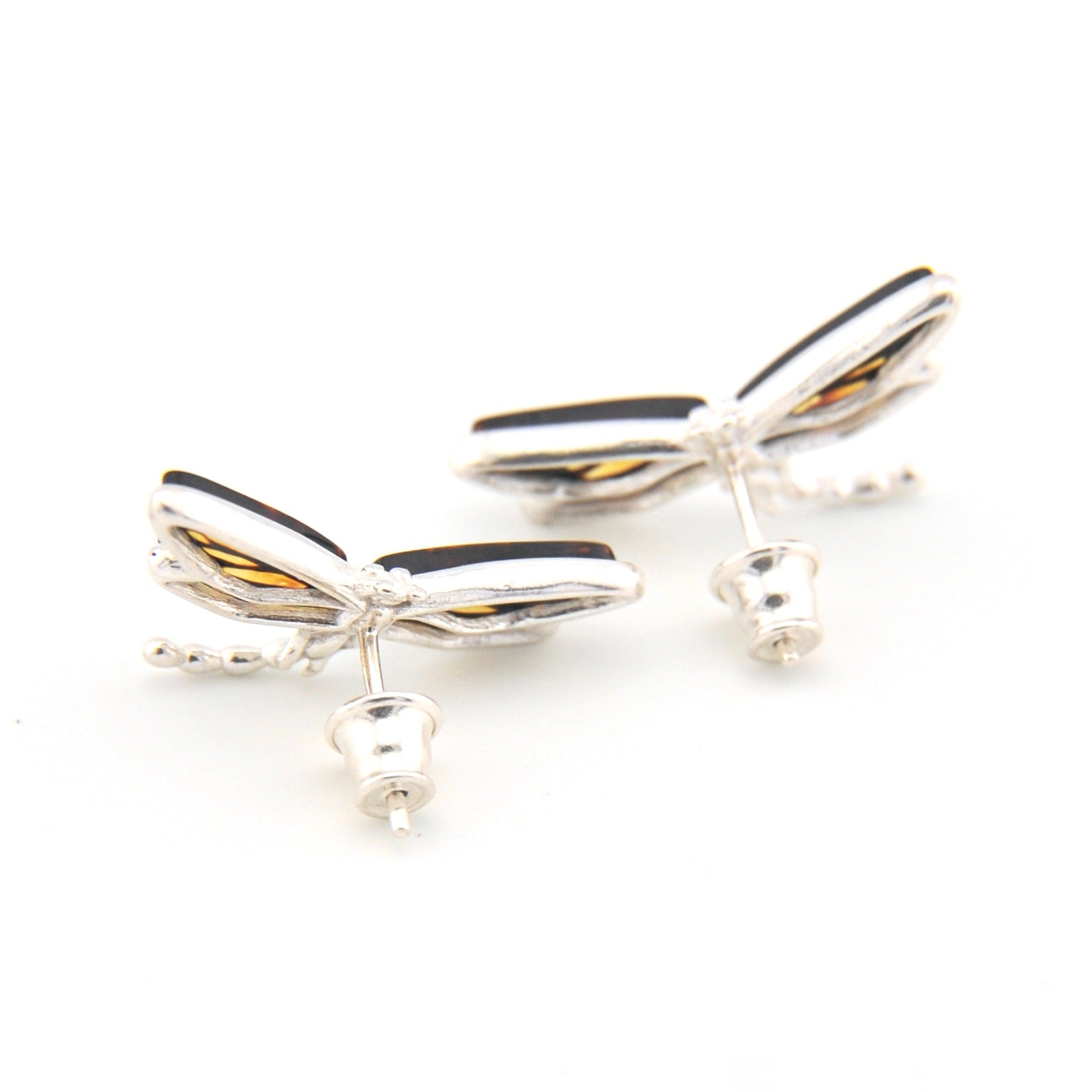 Silver dragonfly-shaped earrings on a white background