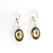 Sunflower earrings with black and gold design on a white background