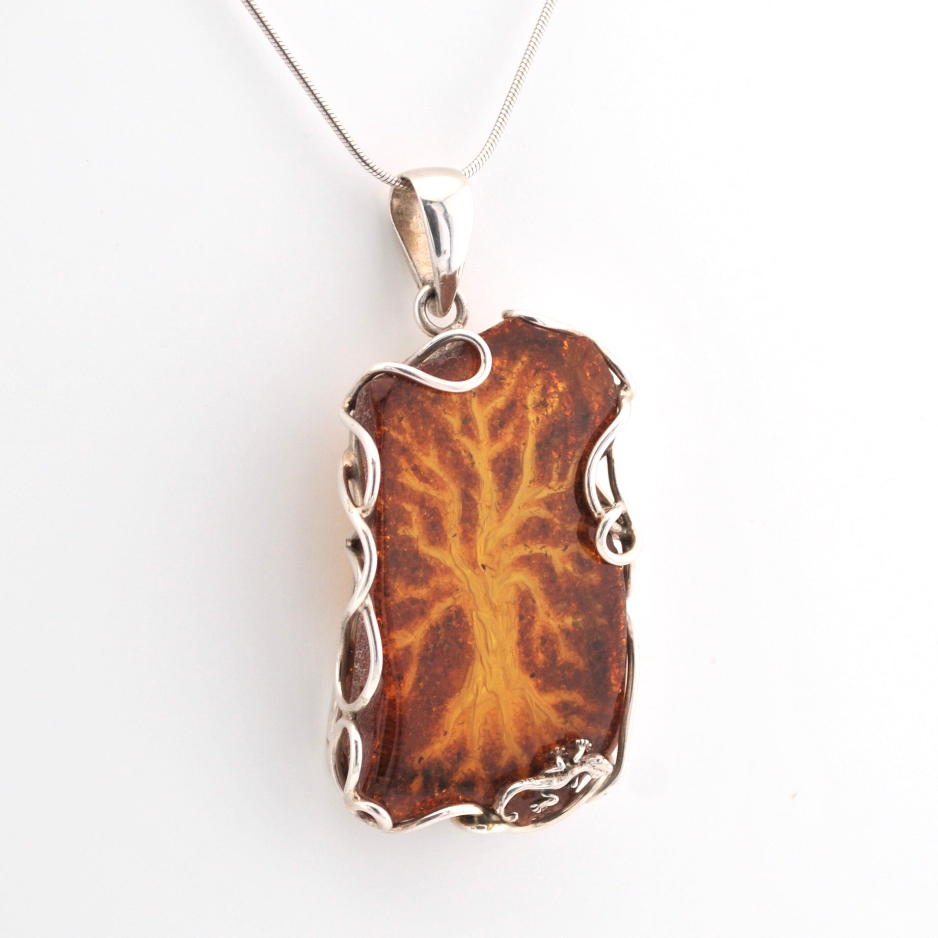 Brown pendant with silver frame on a white background