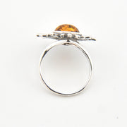 Silver ring with a yellow gemstone on a white background