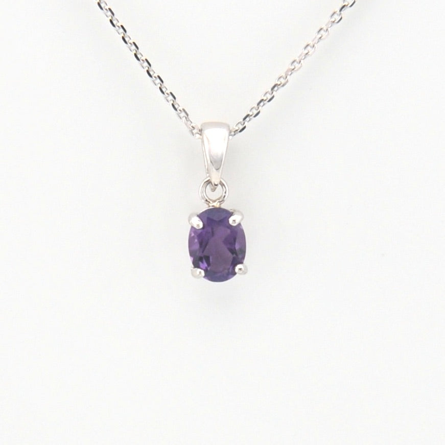 Purple gemstone pendant on a silver chain against a white background