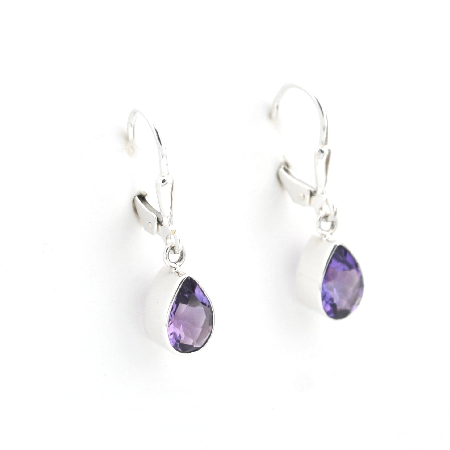Silver earrings with purple teardrop-shaped gemstones on a white background