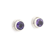 Pair of silver earrings with purple gemstones on a white background