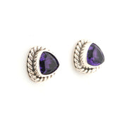 Pair of silver earrings with purple gemstones on a white background