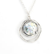 Silver necklace with a round pendant on a white background