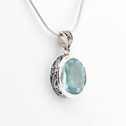 Silver pendant with a blue gemstone on a white background