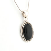 Silver necklace with a black pendant on a white background