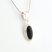 Silver pendant with a black stone on a white background