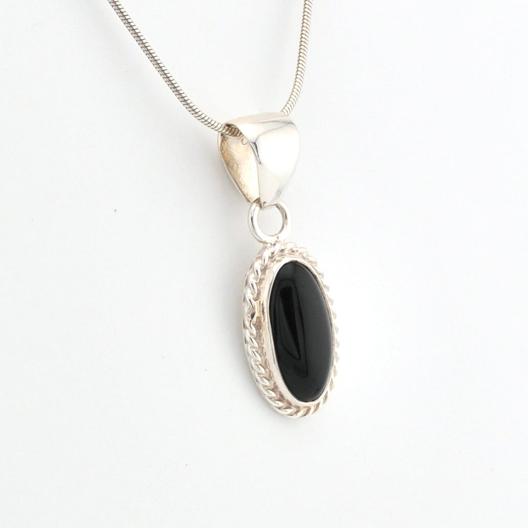 Silver pendant with a black stone on a white background
