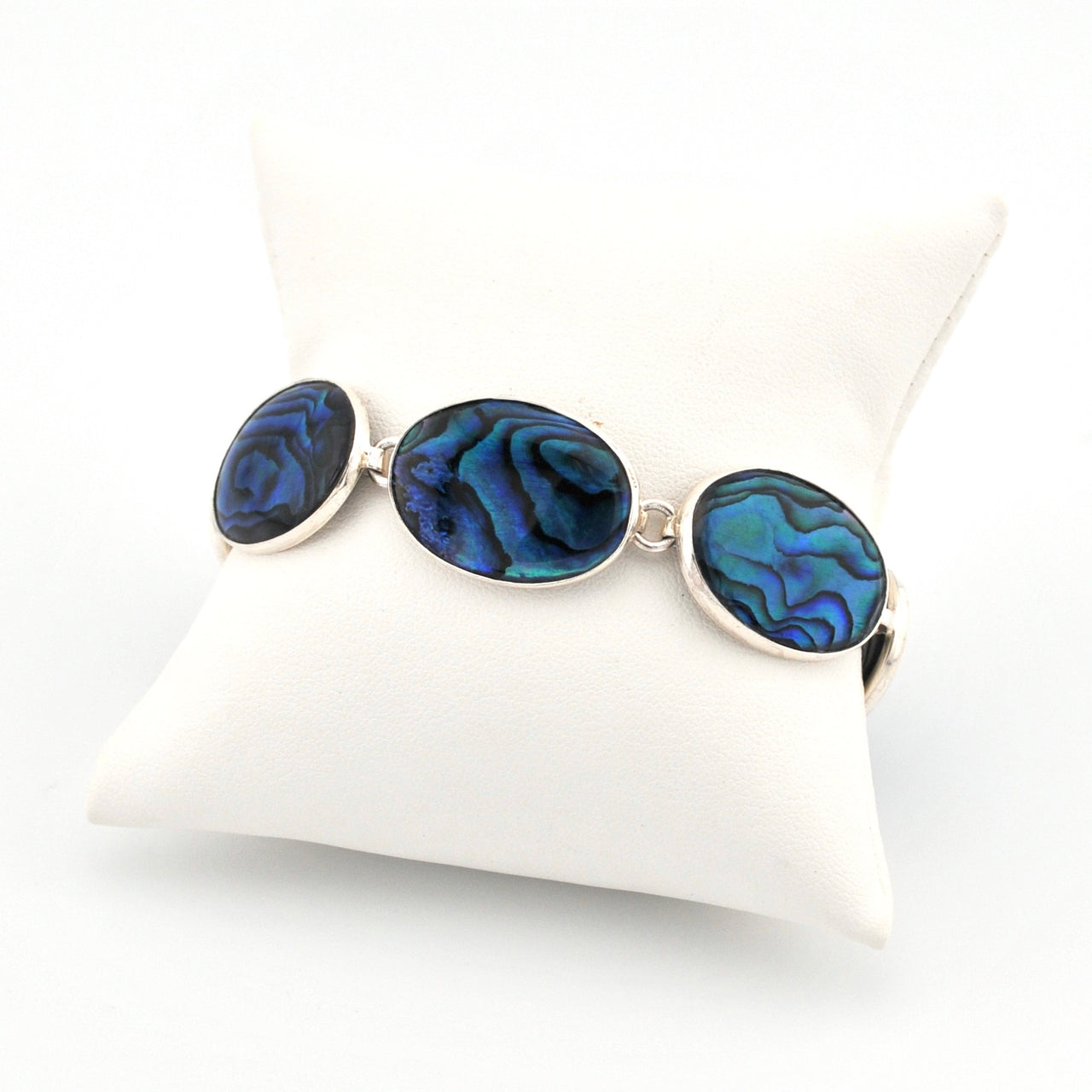 Bracelet with blue oval abalone on a white cushion