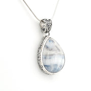 A silver pendant necklace featuring a teardrop-shaped light blue and white marbled stone, set in an ornate silver bezel with a delicate silver chain, shown against a plain white background.