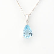 Teardrop-shaped blue gemstone pendant on a white background