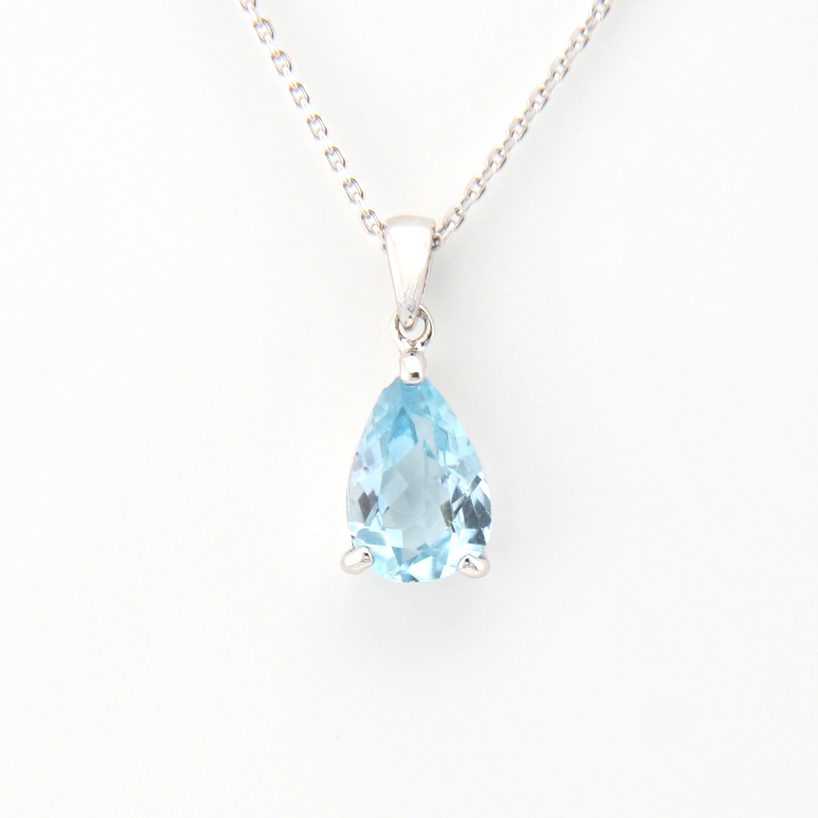 Teardrop-shaped blue gemstone pendant on a white background
