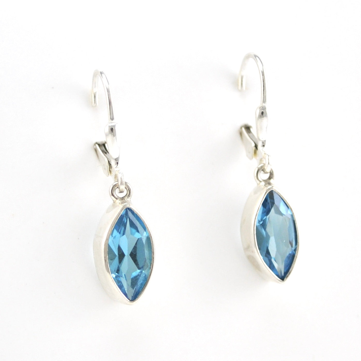 Blue topaz marquise earrings on white background.