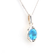 Silver pendant with a blue gemstone on a white background
