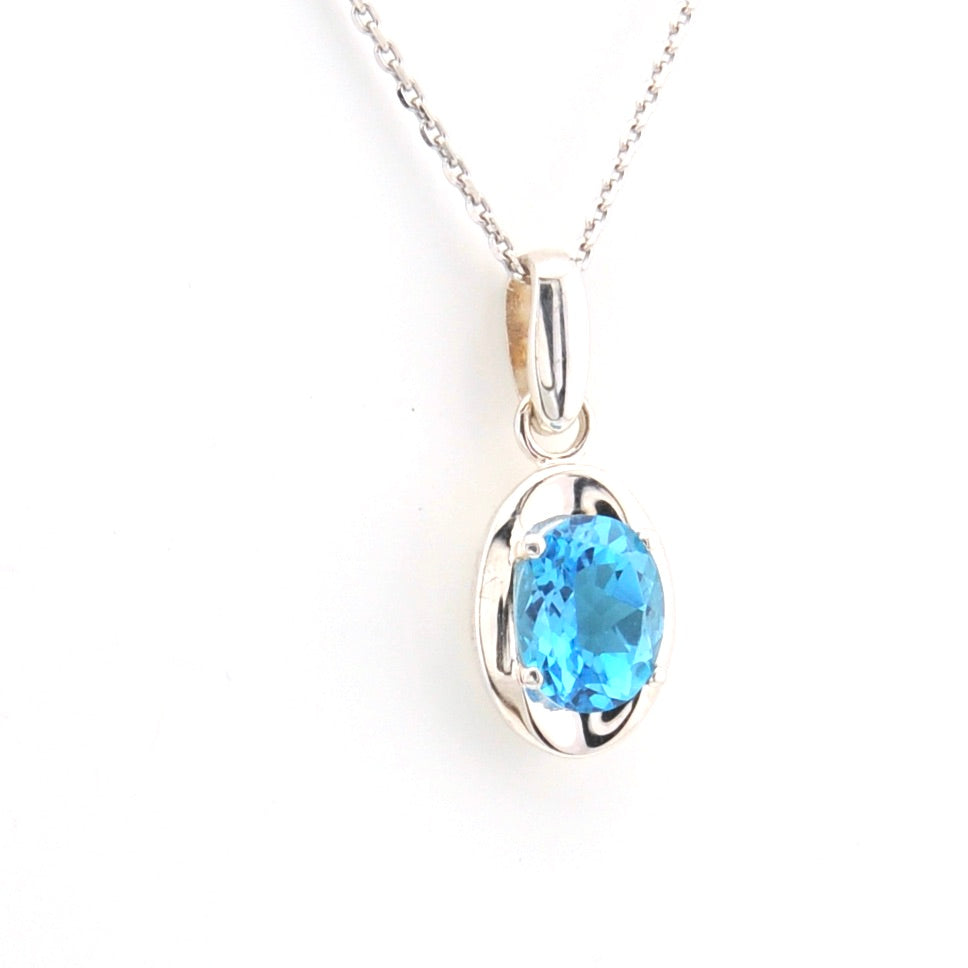 Silver pendant with a blue gemstone on a white background